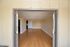 Inviting open space with polished wooden flooring and neutral walls, perfect for modern living.