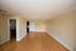 Bright and airy living area with wooden floors and neutral walls, featuring modern lighting fixtures.