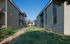 Charming apartment complex with brick exteriors, lush green lawns, and stairway access.