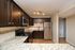 Modern kitchen with dark wood cabinets, granite countertops, and stainless steel appliances.