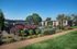 Beautiful apartment complex with lush gardens and manicured pathways under a clear blue sky.