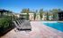 Inviting outdoor pool area with elegant lounge chairs lined up on a sunlit patio.