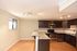 Contemporary kitchen with dark wood cabinets, stainless steel appliances, and elegant granite countertops.