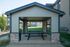 Quaint outdoor pavilion with picnic tables, surrounded by lush greenery.