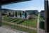 Balcony view of a charming apartment complex with a central swimming pool and lush landscaping.