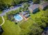 Aerial view showcasing a vibrant residential community with outdoor pool, modern apartments, and lush green spaces.