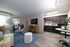 Contemporary apartment living room with chic furniture and a sleek kitchen featuring stainless steel appliances.