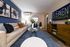 Inviting living room with modern decor, featuring a plush sofa, stylish artwork, and elegant wooden furniture.