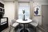 Cozy dining area with a round table, modern chairs, and elegant decor, featuring a stylish kitchen setting.