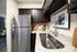 Elegant kitchen featuring granite countertops, dark wood cabinets, and stainless steel refrigerator.