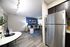 Stylish apartment interior featuring a modern living room with a blue accent wall, cozy seating, and a sleek kitchen area.