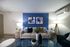 Stylish living room with modern decor, featuring a cozy sofa, abstract art, and accent lighting.