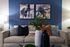 Elegant living room with a stylish beige sofa, two abstract paintings, and vibrant decor pieces.