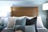 Inviting bedroom with a wooden headboard, plush pillows, and elegant lighting.