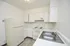 Bright, modern kitchen with sleek appliances and ample cabinetry for a minimalist living experience.