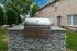 Elegant outdoor grill on a stylish stone countertop, surrounded by lush greenery and modern brick architecture.