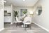 Modern dining nook with elegant chairs, a round table, and stylish decor adjacent to a sleek kitchen in a contemporary apartment.