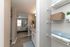 Inviting hallway view showcasing modern shelving, soft lighting, and a glimpse into a cozy, elegantly furnished bedroom.