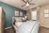 Inviting bedroom with modern decor, featuring a cozy bed, elegant teal accent wall, and soft lighting.