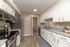 Modern kitchen with sleek stainless steel appliances, granite countertops, and white cabinetry, perfect for stylish culinary adventures.