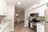 Modern kitchen with sleek stainless-steel appliances and granite countertops leading to a cozy dining area, perfect for entertaining.