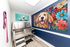 Bright pet grooming area in an apartment with vibrant dog-themed artwork and modern stainless steel washing station.