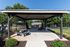 Charming outdoor pavilion with picnic tables and a stylish grill area, surrounded by lush greenery and vibrant flowers, perfect for community gatherings.