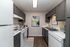 Modern kitchen with sleek gray cabinets, white appliances, and elegant decor, offering a stylish and functional space.