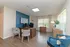 Bright and inviting home office space with modern furniture, blue accent wall, and large windows providing natural light.