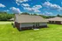 Charming suburban home surrounded by lush green lawn under a vibrant blue sky with fluffy clouds.