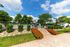 Inviting outdoor pool area surrounded by lush greenery and vibrant flowers, perfect for relaxation and leisure under a clear blue sky.