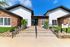 Inviting leasing center entrance with modern design, featuring stone accents and lush greenery under a bright blue sky.