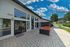 Modern apartment complex patio with stylish seating, lush greenery, and vibrant blue sky, offering a relaxing outdoor space.