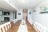 Inviting dining area with a stylish wooden table, elegant decor, and view of a cozy living space with a modern fireplace.