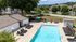 Inviting outdoor pool area with sun loungers and well-maintained landscape, perfect for relaxation and leisure.