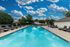Luxurious outdoor swimming pool with lounge chairs under a vibrant blue sky, perfect for relaxation and sunbathing.