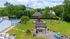 Inviting outdoor community space features a sparkling pool, vibrant playground, and cozy fire pit area surrounded by lush greenery.