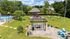 Charming outdoor community space featuring a playground, swimming pool, and a cozy BBQ area with Adirondack chairs, perfect for relaxation and fun in a serene setting.