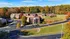 Charming aerial view of brick apartment buildings surrounded by lush autumn foliage, offering serene, suburban living.