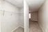 Spacious walk-in closet with ample shelving and cozy carpeted hallway in a modern apartment.