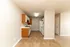 Charming kitchen with wood cabinetry, sleek countertops, and modern appliances leading to an open living area.