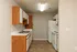 Charming kitchen with classic cabinetry, modern appliances, and sleek countertops in a cozy apartment setting.