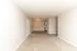 Bright and spacious apartment interior featuring a cozy carpeted living area, elegant chandelier, and modern kitchenette with tiled flooring.