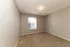 Bright and inviting room with soft carpeting and a sunlit window, ready for personal touch and decor.