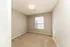 Bright and inviting empty bedroom with soft beige carpeting, a large window for natural light, and neutral wall colors. Perfect for personalization and comfort.