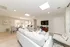 Bright and inviting open-concept living and dining area with modern decor, featuring a cozy sofa, sleek dining set, and flat-screen TV, perfect for entertaining.