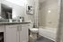 Modern bathroom with granite countertop, elegant fixtures, and tasteful decor, featuring a stylish shower curtain and clean white cabinetry.