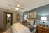 Cozy bedroom with modern decor, featuring a plush bed, elegant artwork, and soft lighting for a relaxing atmosphere.