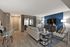 Modern living room with elegant decor, featuring a cozy seating area, stylish accent wall, and chic flooring.