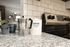 Cozy kitchen corner featuring a chic espresso maker, stylish coffee canister, and modern stovetop on speckled granite countertops.